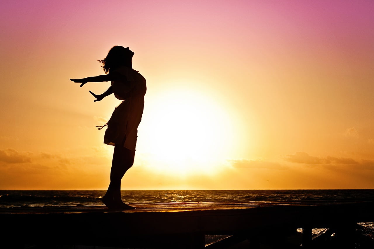 Woman blissful stretch at sunset