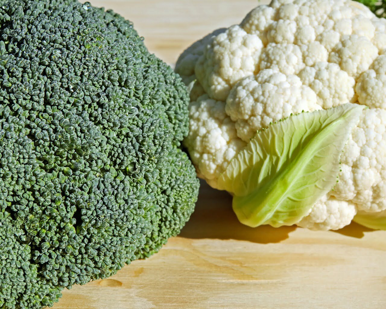 Cauliflower and Broccoli heads on table