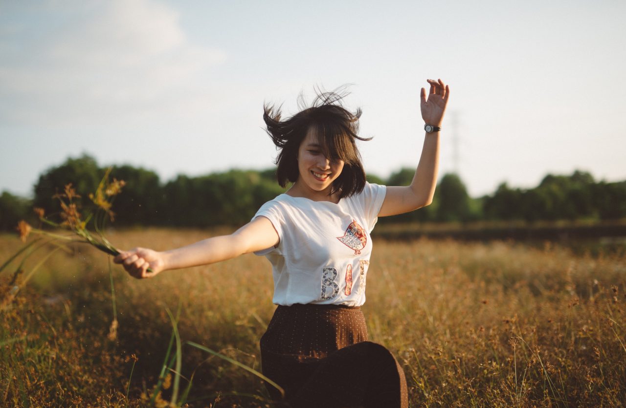 Lady pulling grass in field