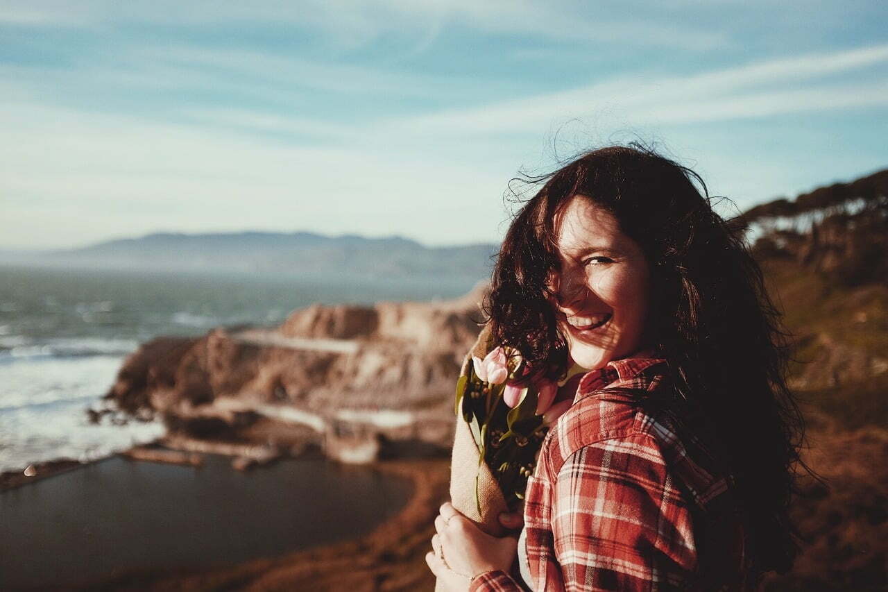 Woman Laughing While Wind Blows Hair in Her Face