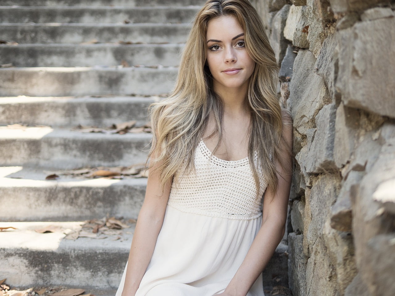 Young lady leaning against rock wall