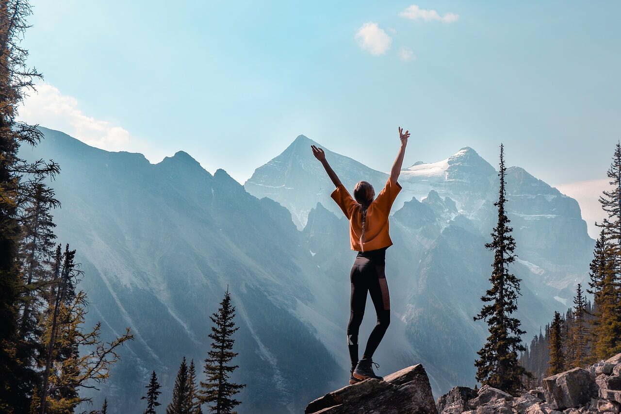 Happy Woman Raising Arms toward Sky