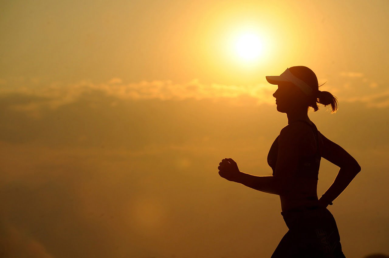 woman running with sun