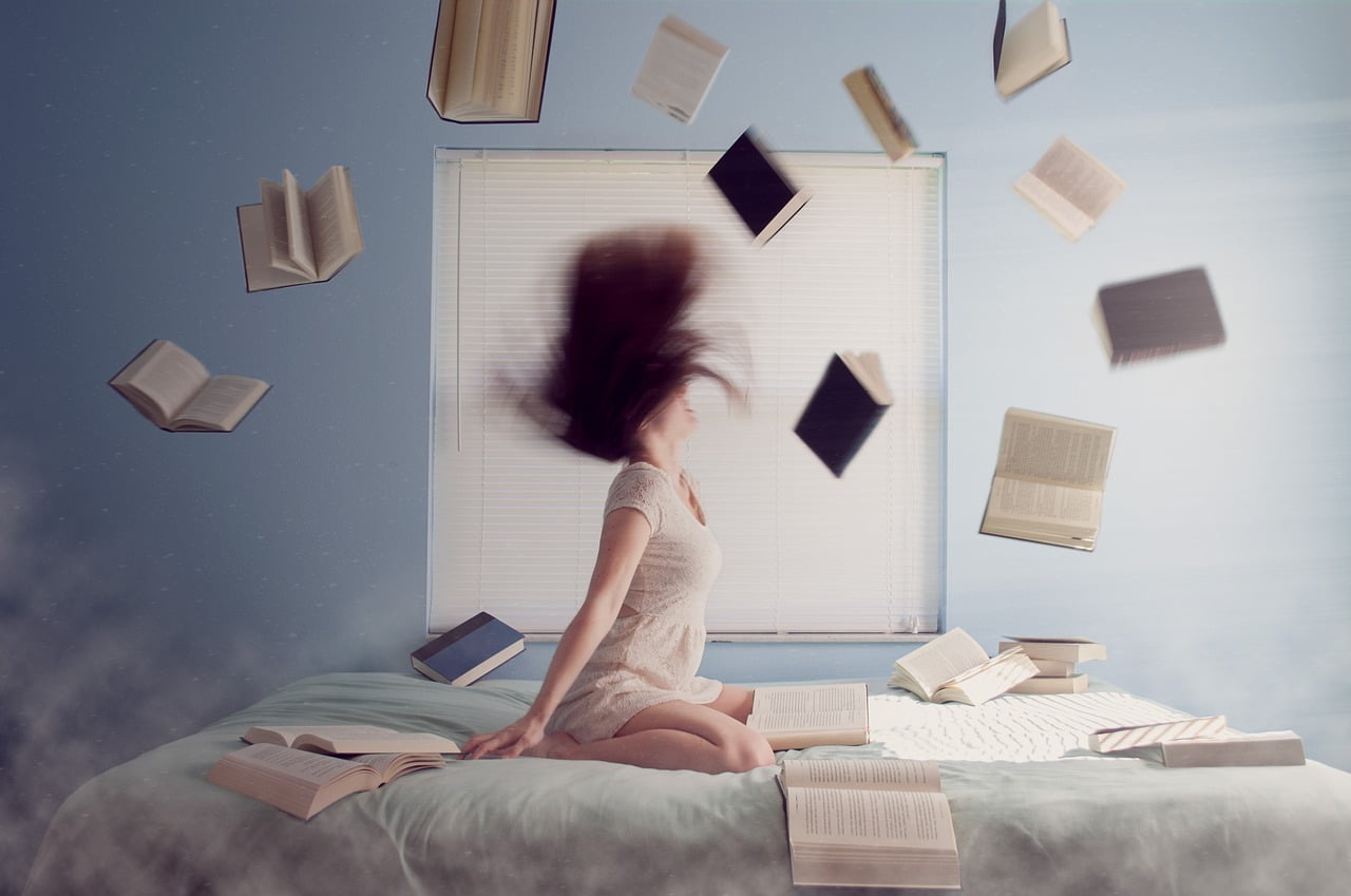 woman on bed with books