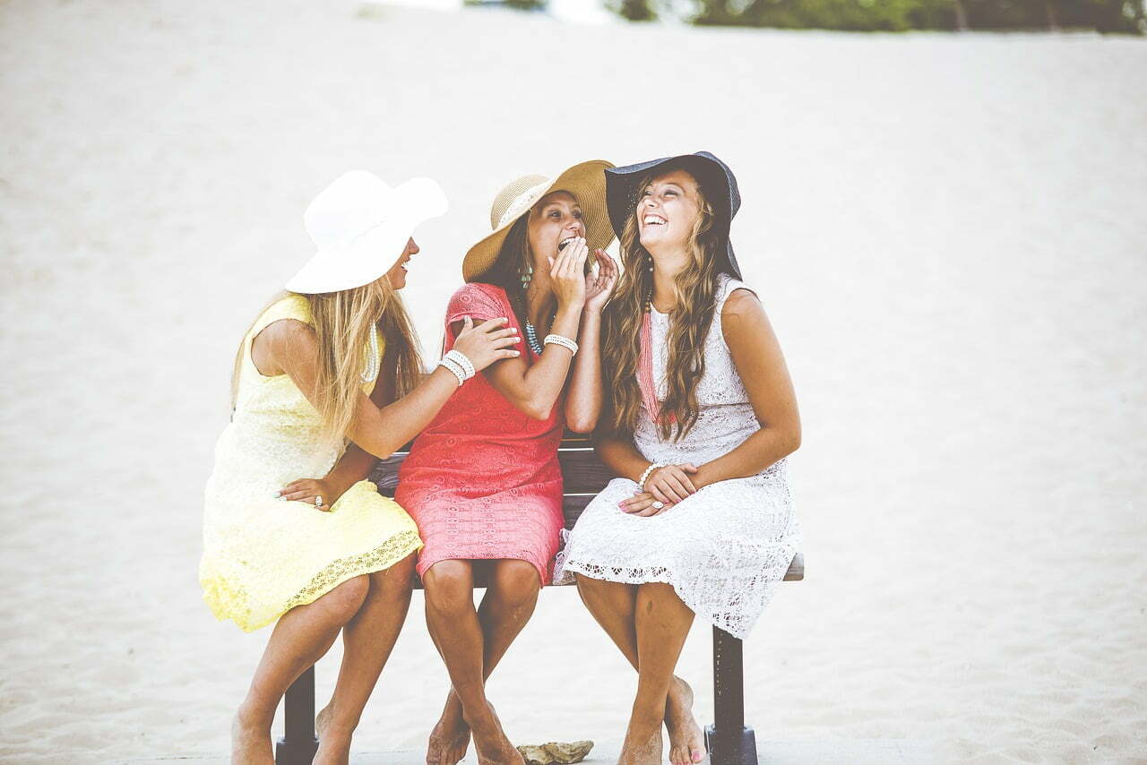 3 women laughing on beach