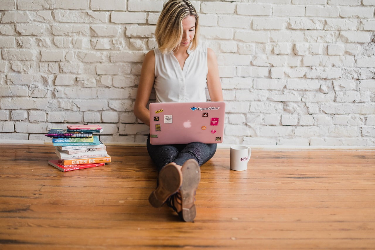 woman on floor on pink laptop