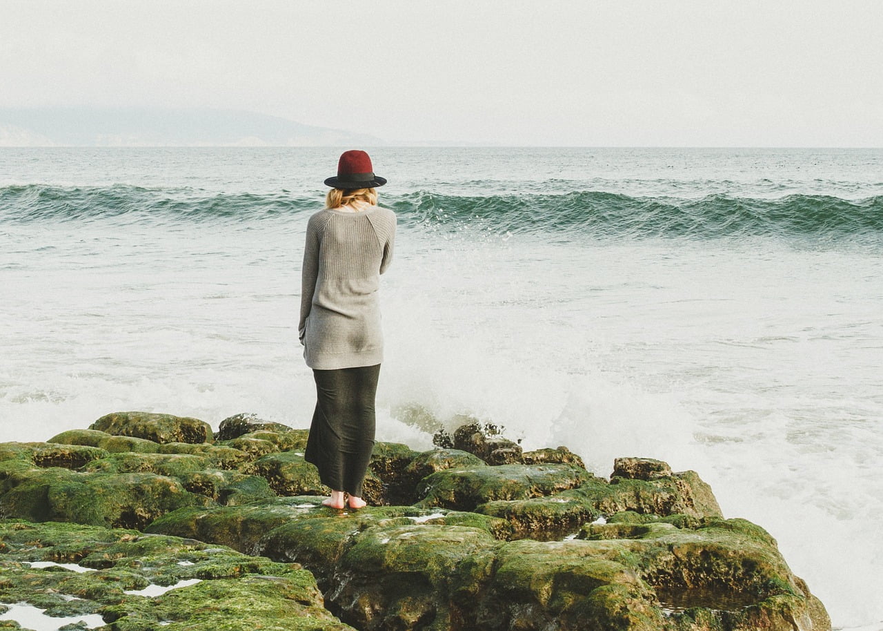 woman on rocks near ocean