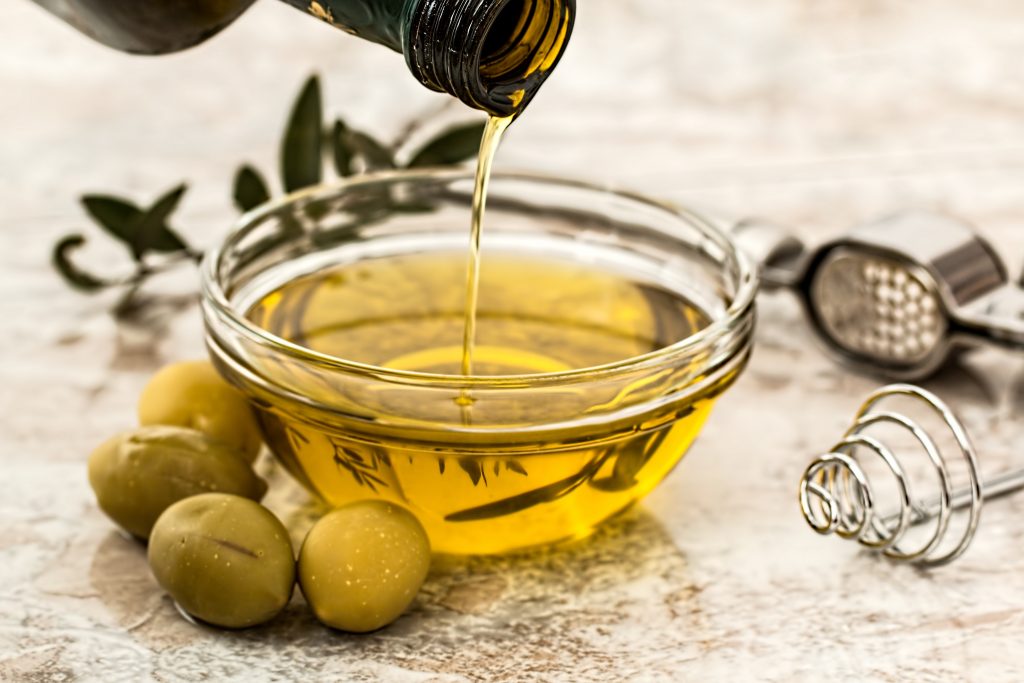 A picture of a bottle pouring olive oil into a bowl